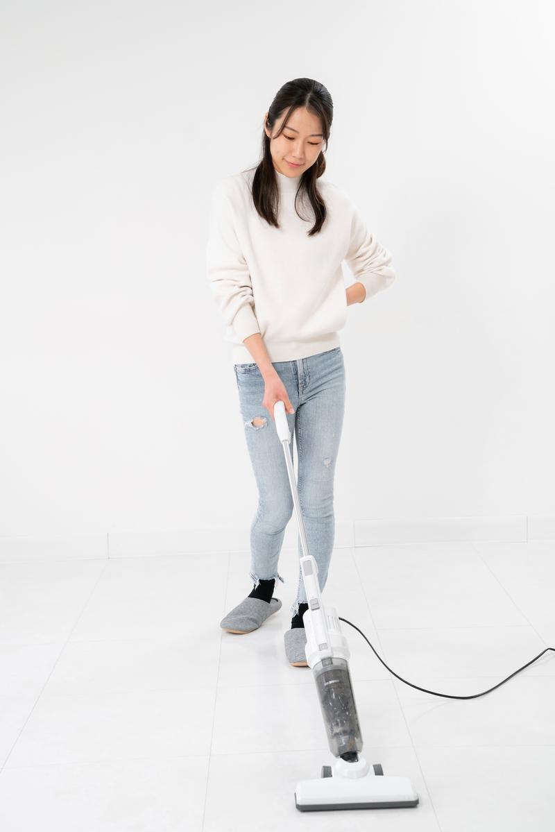 掃除機を使ってお部屋をお掃除する女性［モデル：SAKI］