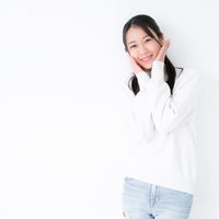 頬に手を添えてはにかむ女性のポーズの写真