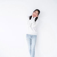 頬に手を当てて照れ笑いする女性のポーズの写真