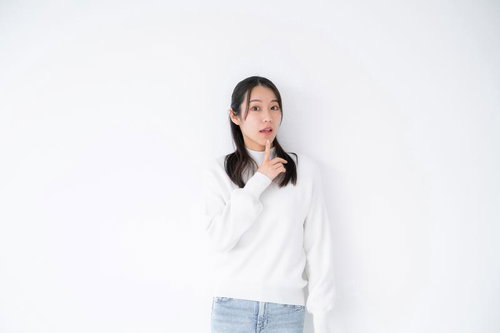 驚きのリアクションをする白い長袖の女性の顔と仕草