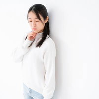 考え込む表情で目を伏せる女性のポートレートの写真