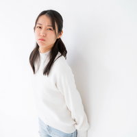 ムスッと不機嫌な表情の女性、眉をひそめて不満そうな顔の写真