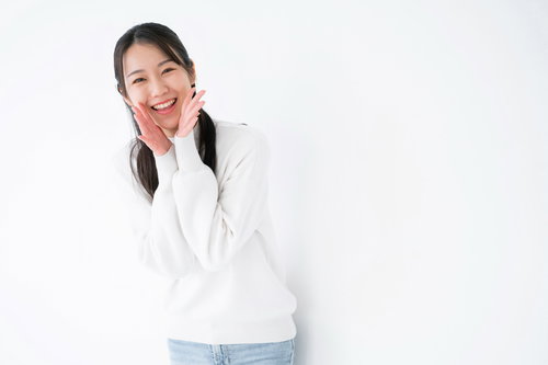 白背景で笑顔で声援を送る女性のポーズ