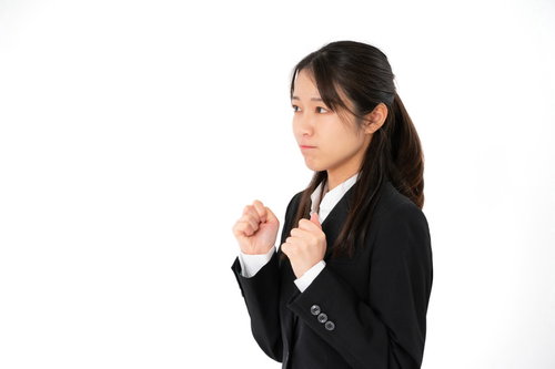 グッと我慢するスーツ姿の女性社員