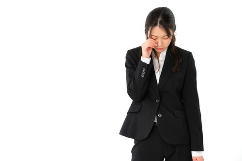 成果がでないで落ち込み泣く黒いスーツの女性社員