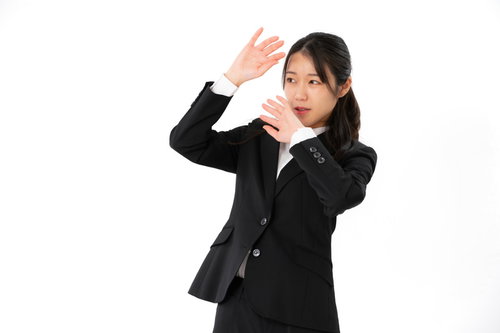 暴力を振るわれて顔を覆い怯える女性社員のパワハラ表現