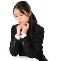 悩みを聞いてほしい素振りを見せる黒スーツの女性の写真