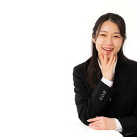 黒いスーツで笑顔で会話をする女性社員との対話シーンの写真
