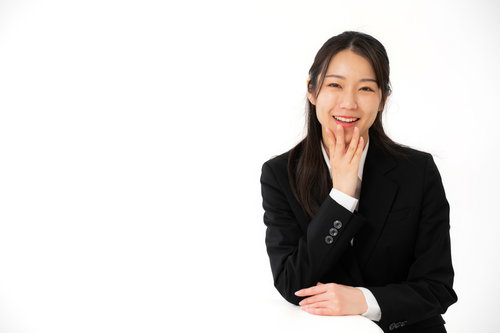 黒いスーツで笑顔で会話をする女性社員との対話シーン