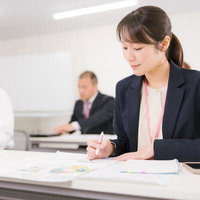 ミーティング中に資料を読み解く女性オフィスワーカーの写真