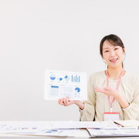 データ分析結果のレポートを手に説明する女性アナリストの写真