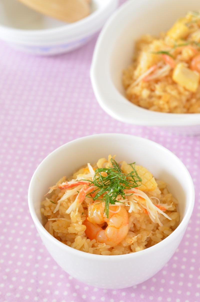 白い器に盛られた蟹の炊き込みご飯。蟹とえび、新生姜、刻み葱がのっている
