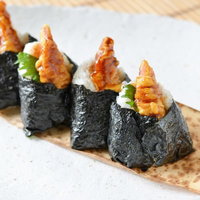 海老天を乗せた天むす4つ、木製プレートに一列に並べた盛り付けの写真