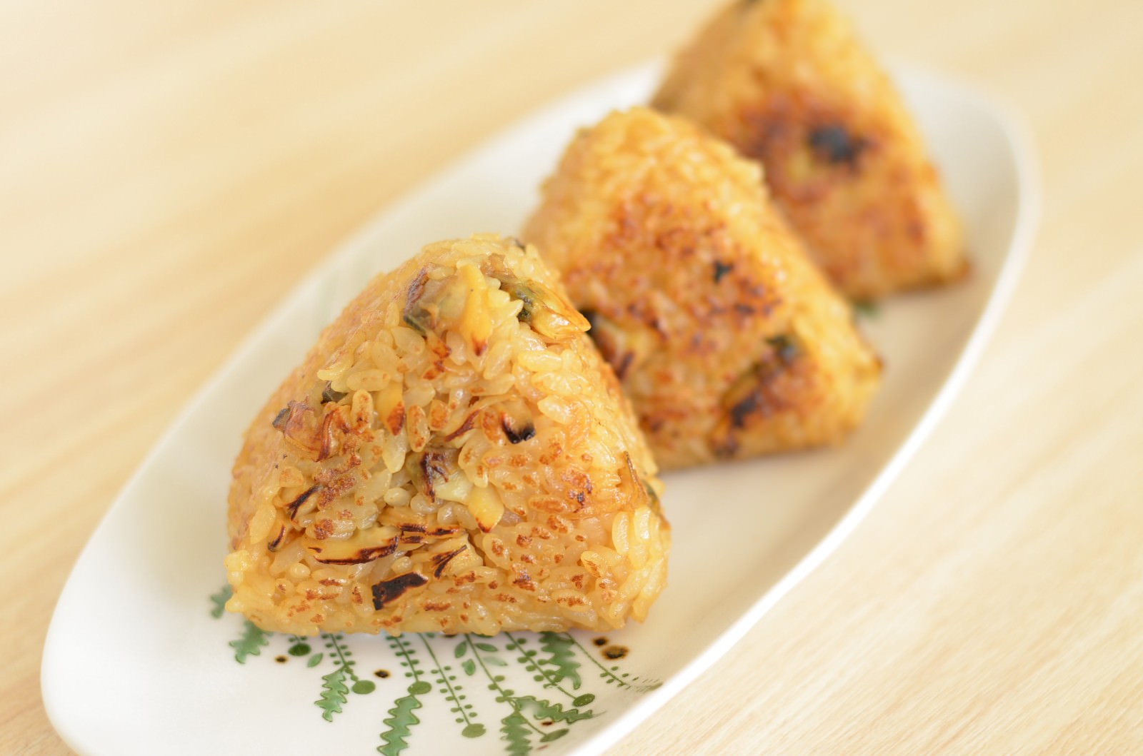 白い皿に並んだあさり入り焼きおにぎり3個と茗荷