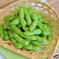 竹ざるに盛られた枝豆のおつまみ、ビールや晩酌に最適な居酒屋の定番メニューの写真