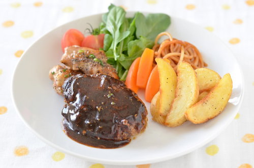 ソースをかけたハンバーグとポテトの夕食プレート