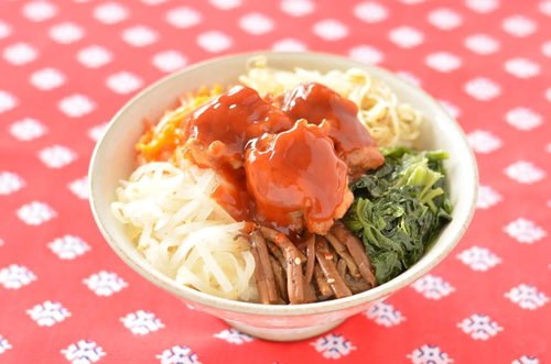 唐揚げがのった白丼のビビンバ、卵黄とナムルを添えたランチ丼の写真