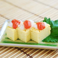 めんたい卵焼きを白い皿に盛り付けた和風おかず料理の写真