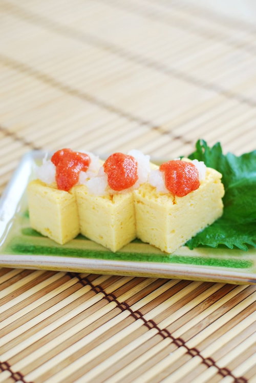 めんたい卵焼きを白い皿に盛り付けた和風おかず料理の写真