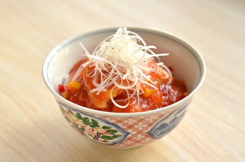 白い糸削り削魚がのった酢豚丼の盛り付け