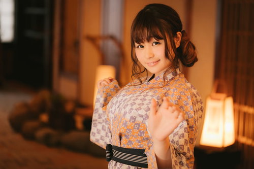 温かい照明の中で白地花柄の旅館浴衣を着た彼女