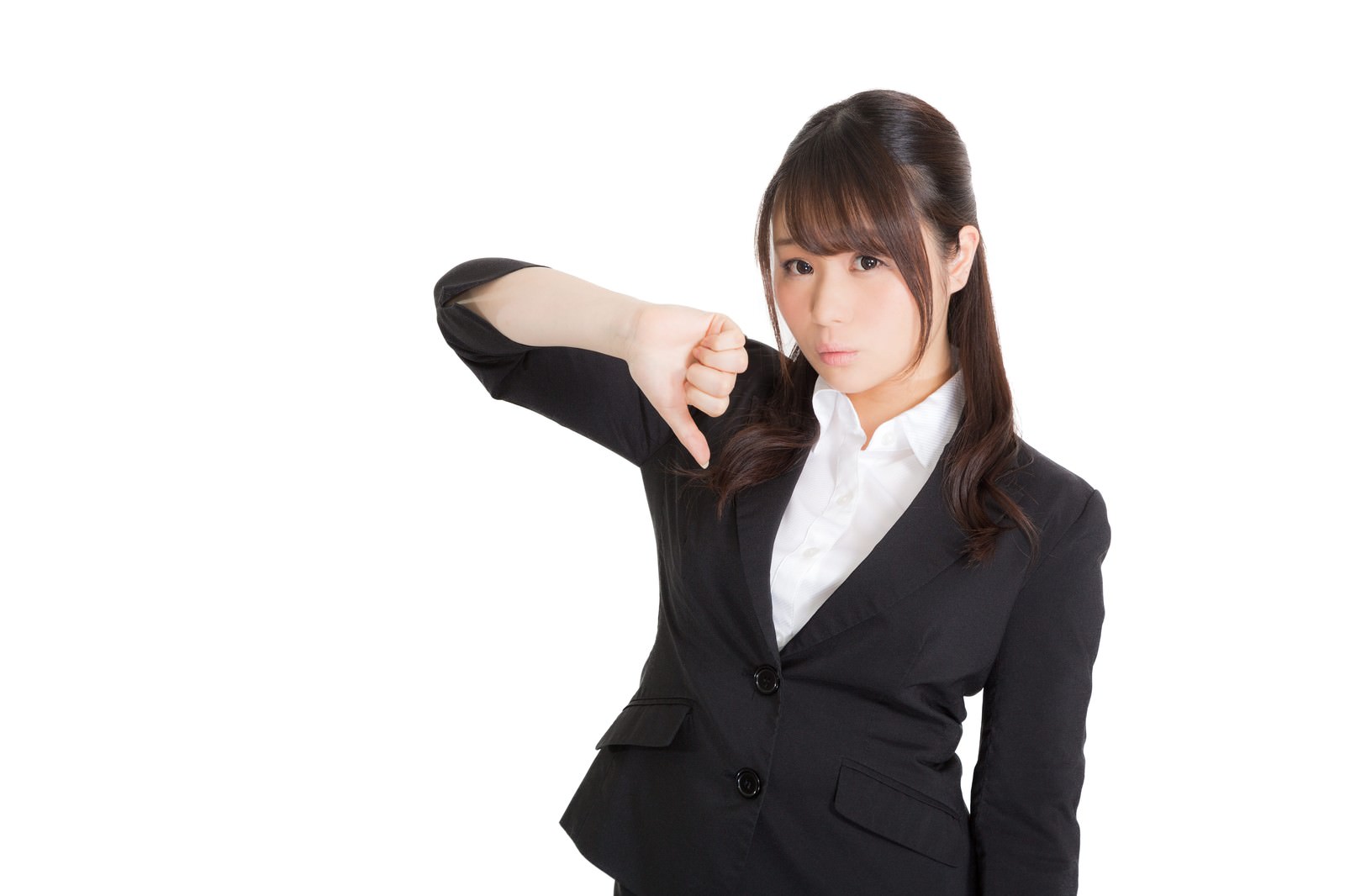 黒いスーツを着た女性が親指を下にして不可のジェスチャーをしている［モデル：茜さや］