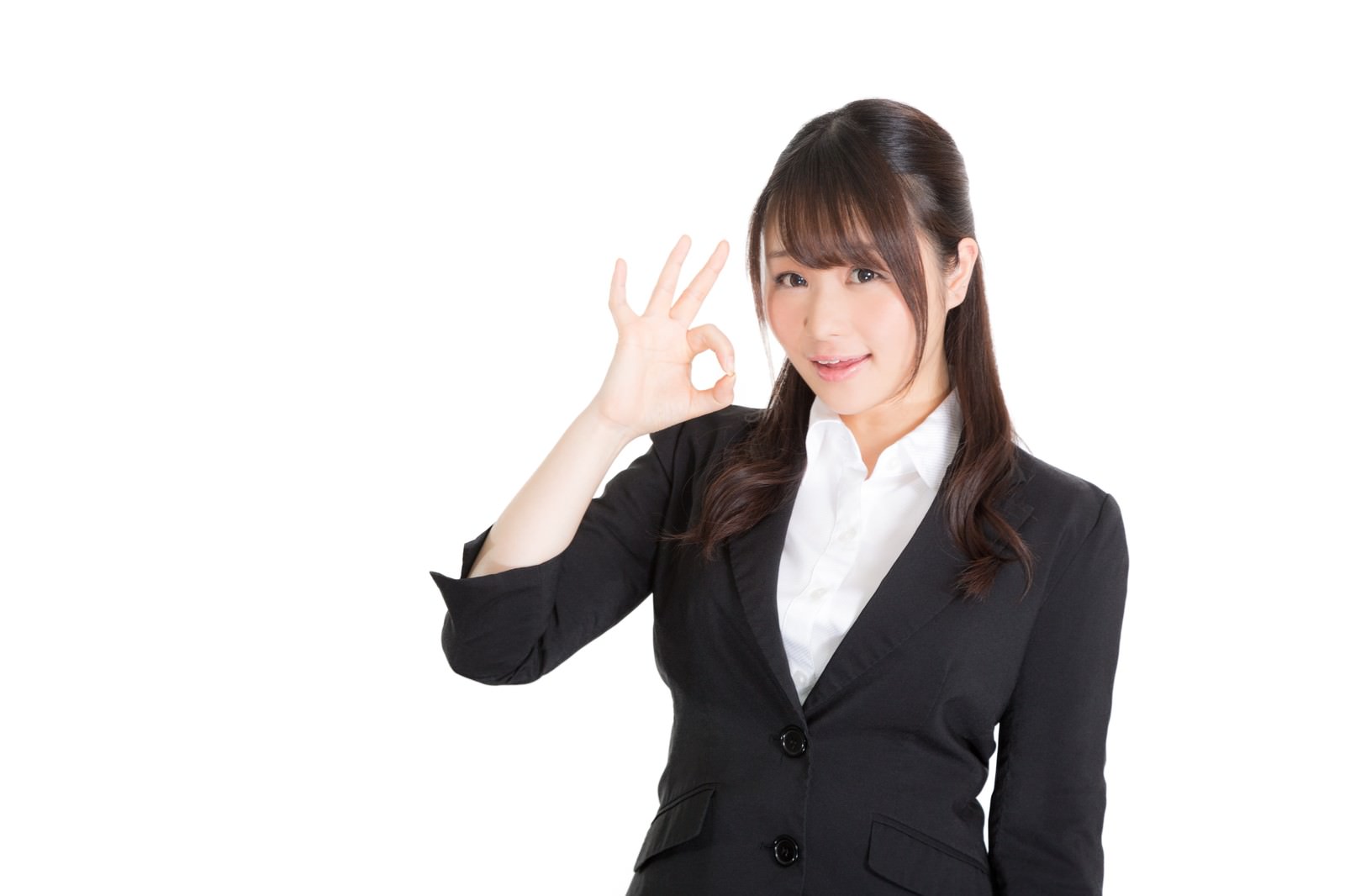 黒いビジネススーツの女性がOKサインを出しながら笑顔で正面を向いている［モデル：茜さや］