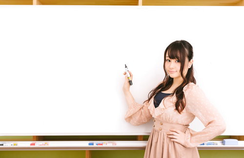 ホワイトボードにマーカーで書いて説明する女性