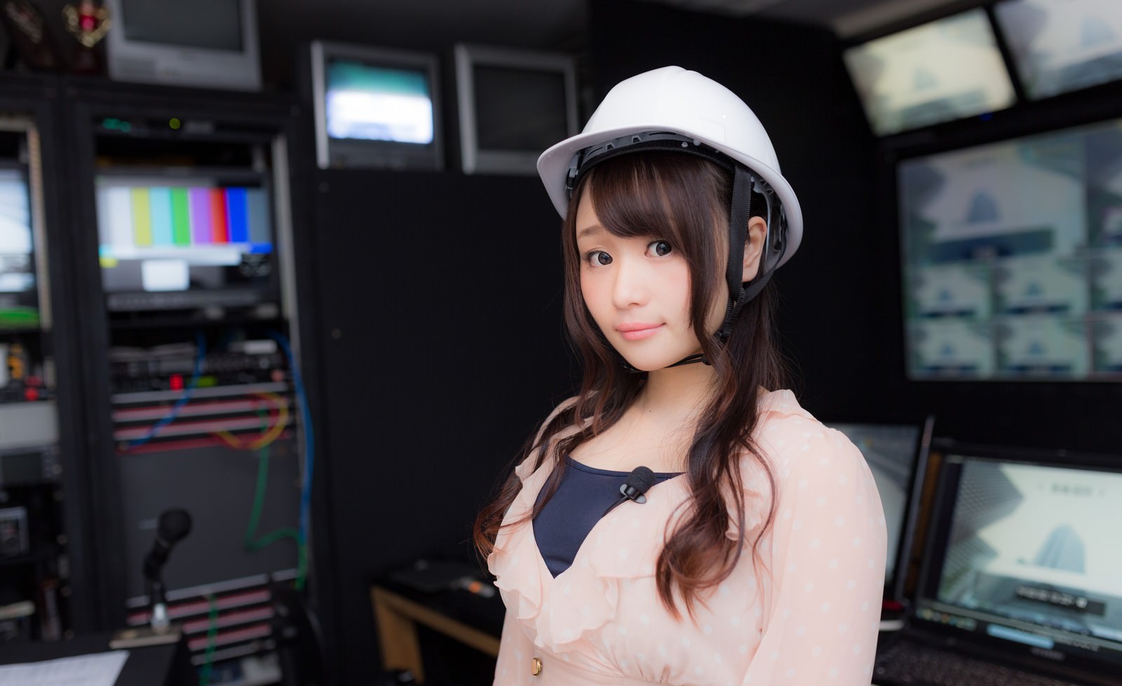 放送室でヘルメットをかぶる女性アナウンサー［モデル：茜さや］