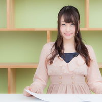 放送局のスタジオでニュースを伝える女性アナウンサーの写真