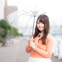 雨の中、傘をさして天気予報を伝えるキャスターの写真