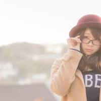 夕暮れの中、眼鏡をかけた女性のポートレートの写真