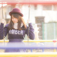 公園のブランコで揺られているピンク帽子の女性の写真
