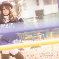 ブランコの柵が邪魔です。紫のスウェットを着た女性の写真