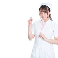 ピンク聴診器を持ったナース姿の女性のポートレートの写真