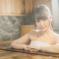 個室の檜風呂に浸かってくつろぐ女性、源泉かけ流しの温泉で贅沢なリラックス時間の写真