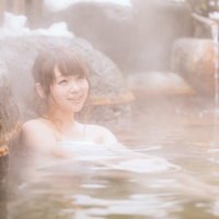 源泉かけ流しの温泉を楽しむ雪見露天風呂の湯けむり女子の写真