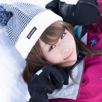 ゲレンデの天使 ピンクのスキーウェア姿で雪の上に寝そべる女性の写真