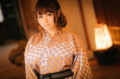 旅館の和室で浴衣姿で待ち合わせする女性