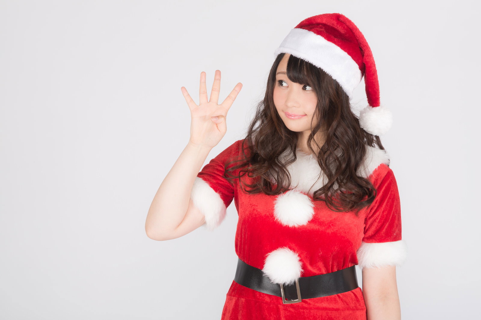 赤いサンタ衣装を着た女性が左手の5本指を立ててカウントダウンポーズをしている［モデル：茜さや］
