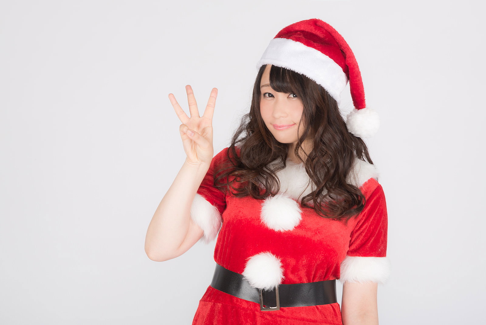 サンタ衣装の女性がピースサインで笑顔を向ける