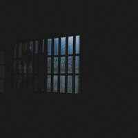 深夜、眠らない隣人のアパート窓明かり、格子窓から漏れる青白い光の写真