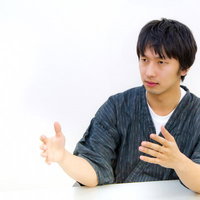 甚平を着て正座しながらろくろを回すジェスチャーの写真