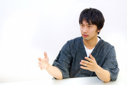 甚平を着て正座しながらろくろを回すジェスチャー