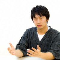 白いテーブルでドヤ顔のろくろ回しジェスチャーの男性の写真