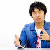 白い背景の前で両手を広げてジェスチャーする男性の写真