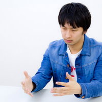 スーツ姿でWEB業界風にろくろを回すジェスチャーの写真