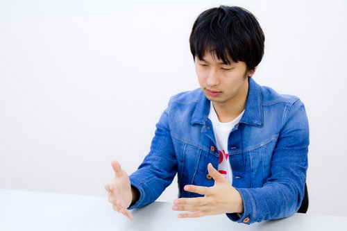 スーツ姿でWEB業界風にろくろを回すジェスチャー