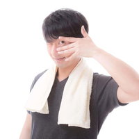タオルを首にかけてニッコリ笑う男性の写真
