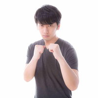 イメージトレーニングで巨大生物と闘うグラップラー男性の写真